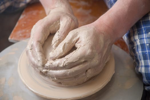 Hands of a potter, creating an earthen jar on the circle