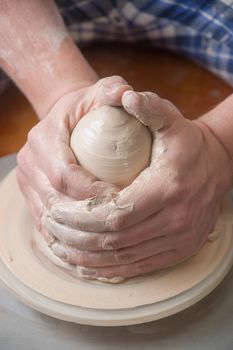 Hands of a potter, creating an earthen jar on the circle