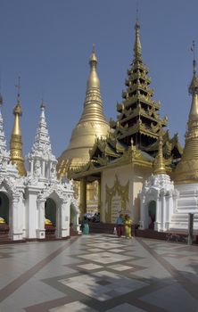 Yangon, Myanmar-May 6th 2014: People stroll through the Shwedagon Pagoda complex.Some structures are reputed to be 2,500 years old.