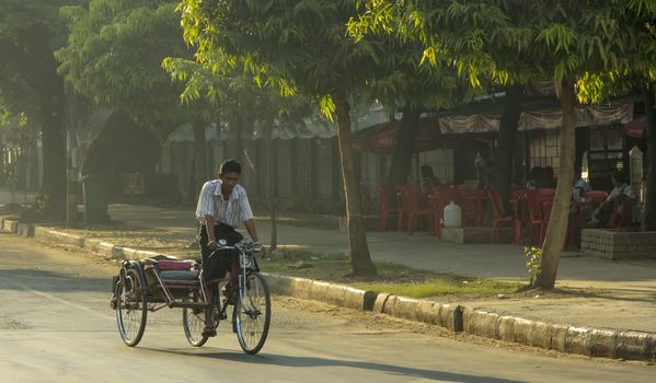 Yangon, Myanmar-May 8th 2014: A rickshaw cycles around the streets in the early morning.As modernisation takes hold rickshaws are disappearing fast from Yangon.