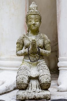 Front view of Thai angel statue in temple, kneel and praying hand state