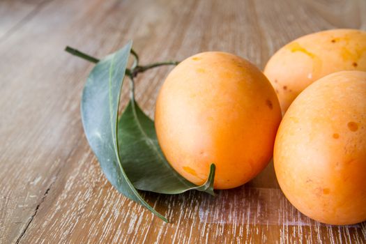 Plum mango, or Marian plum fruit on wooden table