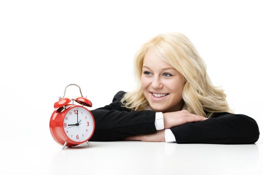 Laughing blond woman with red alarm clock