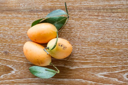 Plum mango, or Marian plum fruit on wooden table