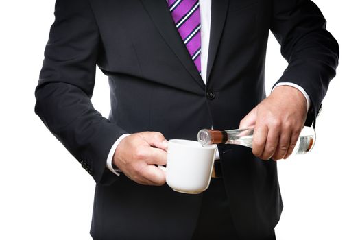 Business man in dark suite with a coffee cup and a bottle with alcohol