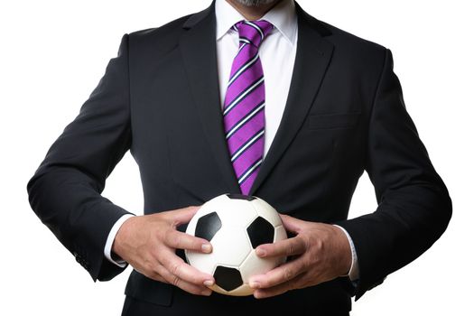 Business man in dark suit and tie holds a soccer ball