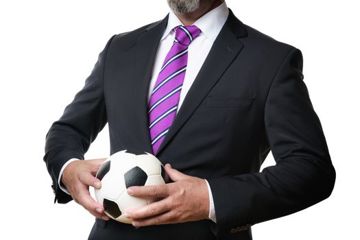 Business man in dark suit and tie holds a soccer ball