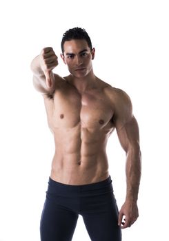 Disappointed or displeased muscular young man doing thumb down sign