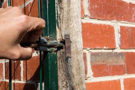 the hand showing the opening the gate of the property