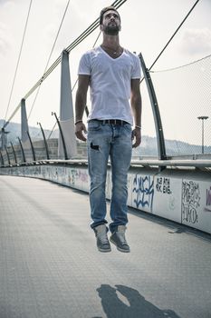 Handsome young man "levitating" in mid-air outdoors in urban environment