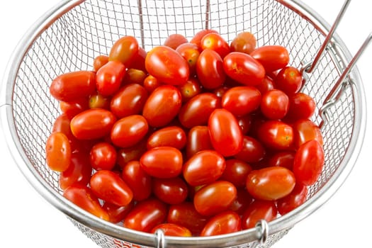 Group of cherry tomatoes in metal basket isolated on white background