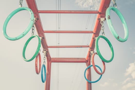 Jungle gym rings and chains with sky background, vintage color toned