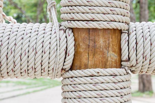 Closeup view of rope tied around wooden pillar