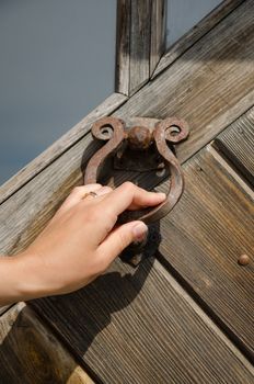 guest hand knock retro rusty metal door handle used as buzzer ringer.