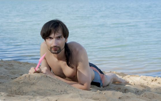 man in a bathing suit on the beach in the sand in the summer