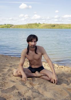 man in a bathing suit on the beach in the sand in the summer