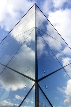 reflexions of clouds and blue sky in glass facade of modern building