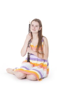 sitting girl in colorful dress with oboe against white background