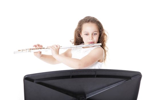 young girl playing flute against white background in studio