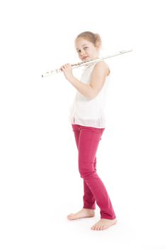 young  girl holding flute standing on the floor of studio with white background