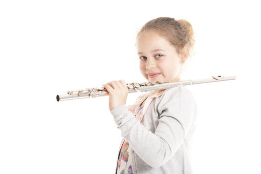 young girl holding flute against white background in studio