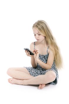 young blond girl with mobile phone in studio against white background