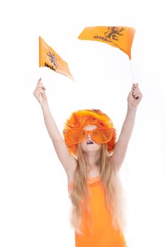 young blond girl with orange wig and hat waving orange flags in studio against white background