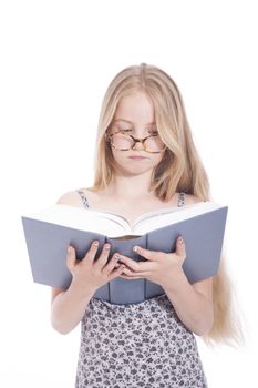 young blond girl with glasses and large book in studio against white background