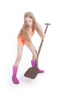 young blond girl working with shovel in studio against white background