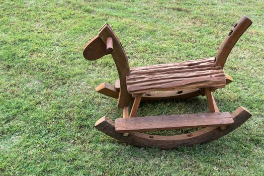 Wooden rocking horse on the grass green.