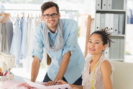 Male and female fashion designers at work in a studio