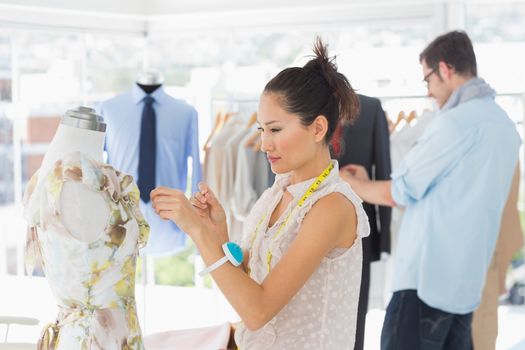 Male and female fashion designers at work in a bright studio