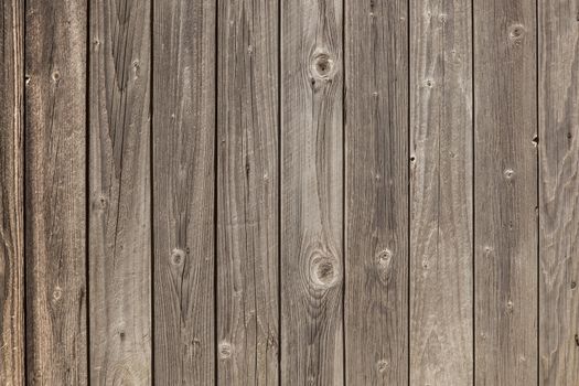 horizontal picture of old grey vertical planks with fading brown paint