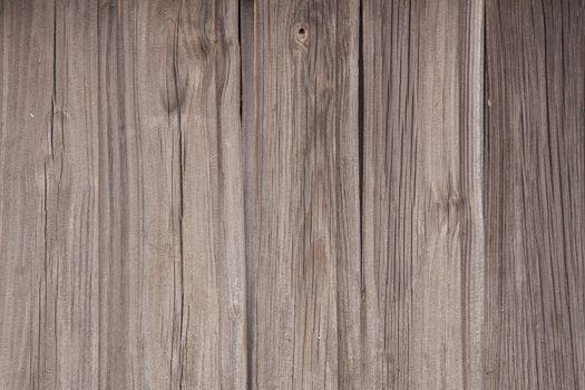 horizontal picture of old grey vertical planks with fading brown paint