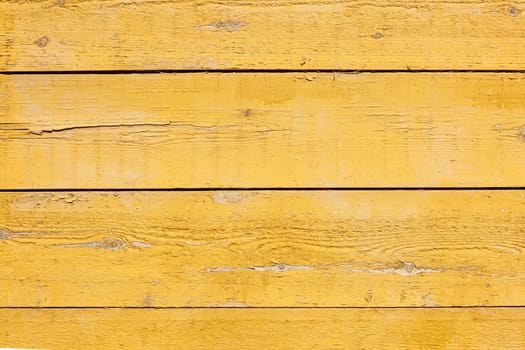 horizontal picture of old horizontal planks with bright yellow paint