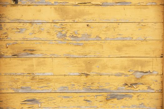 horizontal picture of old horizontal planks with peeling yellow paint