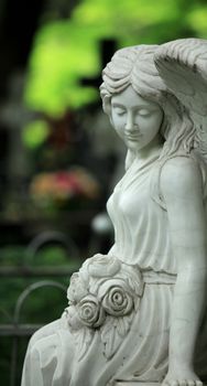 sad angel with flowers close to