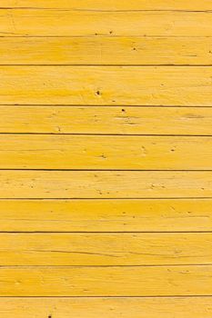 vertical picture of old horizontal planks with bright yellow paint