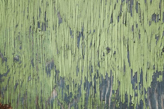 horizontal board with peeling green and blue paint