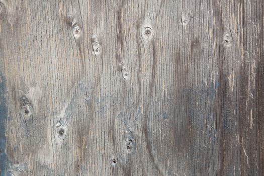 grey wood with knots and remnants of blue paint