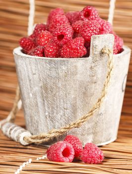 Fresh raspberry in the wooden bucket