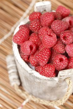 Fresh raspberry in the wooden bucket