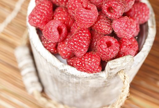 Fresh raspberry in the wooden bucket