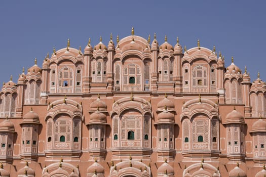Hawa Mahal or Palace of the Winds. Ornate pink facade built to allow ladies of the Royal Court to look into the street without being seen. Jaipur, Rajasthan, India