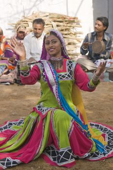 Beautiful tribal dancer in colorful costume performing in Jaipur, Rajasthan, India