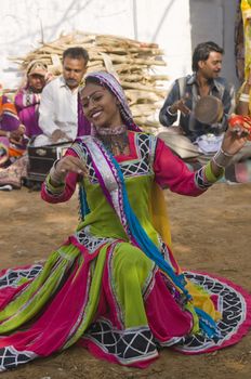 Beautiful tribal dancer in colorful costume performing in Jaipur, Rajasthan, India