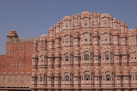 Hawa Mahal or Palace of the Winds. Ornate pink facade built to allow ladies of the Royal Court to look into the street without being seen. Jaipur, Rajasthan, India
