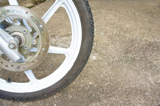 Old black magnesium alloy wheel of motorcycle and disc brake on the left.