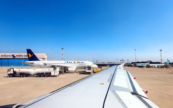 VERONA, ITALY - JUNE 8, 2014: a plane Airbus A320 the Air One, Italian Company is making fuel on the runway of the Airport Valerio Catullo in Verona, Italy