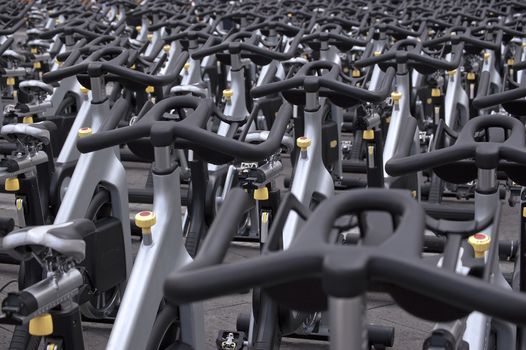 Large group of aluminum exercise bikes outdoors